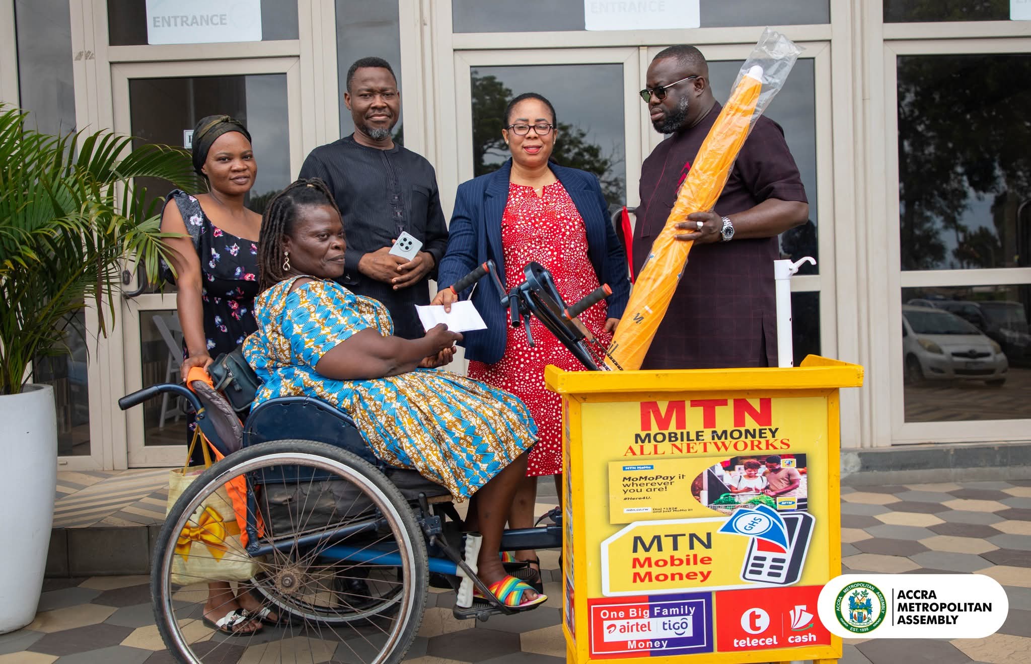 Mayor of Accra supports a physically challenged woman with mobile money vending tools, working capital